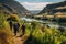 A diverse group of individuals strolling together along a scenic trail that runs alongside a flowing river, Tourists hiking amidst