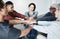 Diverse group of people sitting together in a circle and stacking their hands in the middle after therapy. Smiling