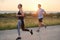 A diverse group of runners trains together at sunset.