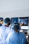 Diverse group of surgeons discussing x rays on screen in operating theatre, copy space