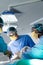 Diverse group of surgeons operating on patient in operating theatre, copy space