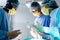 Diverse group of surgeons talking during surgery in operating theatre