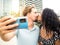 Diverse heterosexual couple in love kissing while taking a selfie. lovers, honeymoon