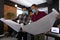 Diverse male colleagues wearing masks in disucssion holding architectural plans in office