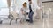 Diverse male doctor helping girl patient use crutches in hospital ward, slow motion