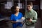 Diverse male and female colleague looking at paperwork and tablet and discussing standing in office