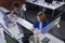 Diverse male and female colleagues sitting in front of computers separated by sneeze shields