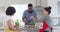 Diverse male and female friends preparing food together in kitchen