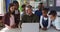 Diverse male teacher and group of schoolchildren looking at laptop