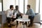 Diverse male workers team listen to manager mentor discussing paperwork