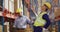 Diverse male workers wearing helmet and touching back in warehouse