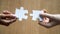 Diverse man and woman hands holding joining pieces connecting puzzle