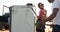 Diverse man and woman using fuel pump filling up truck at petrol station