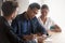 Diverse married couple signing lease contract during meeting in bank