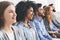 Diverse millennial group sitting in row, waiting for something