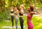 Diverse millennial women on group yoga practice at park on sunny day, copy space