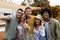 Diverse millennials taking selfie together near camper van, smiling at camera, spending time together on camping trip