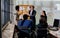 Diverse and multiracial smart businesspeople wearing formal suits, using computer, discussing, meeting, brainstorming together