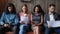 Diverse people candidates waiting for interview, sitting in row