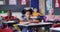 Diverse schoolchildren sitting in classroom raising hands to answer questions during lesson