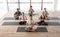 Diverse sporty people attending yoga class in studio, sitting in lotus position