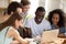 Diverse students watching comedy movie sitting at desk in room