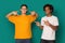 Diverse teens pointing at blank t-shirt over blue background