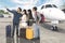 Diverse tourists take a picture near an airplane