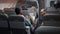 Diverse travellers having conversation in airplane before takeoff