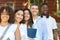 Diverse University Students Standing Outdoors On Campus, Smiling At Camera