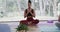 Diverse women with hands on chest practicing breathing exercise in yoga studio