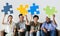 Diverse workers sitting and holding puzzle icons