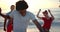 Diverse young friends enjoy a playful moment on the beach at sunset