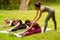 Diverse young girls working out with yoga trainer during outdoor class at park