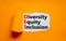 Diversity, equity, inclusion DEI symbol. Words DEI, diversity, equity, inclusion appearing behind torn orange paper. Orange