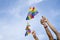 Diversity people hands raising colorful lgbtq rainbow flags in the parade, background blue sky