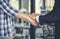 Diversity two business partners shaking hands together with business contract mergers and acquisitions. Close up honest hands