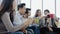 Diversity of young people group team holding coffee cups and discussing something with smile while sitting on the couch at office