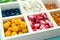 Divided box with different pills on table, closeup