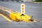 Dividing median curb on road with white and yellow warning reflecting sign