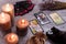 Divination cards alignment with black Buddha statue, money banknotes and candles. Mystery, astrology, fortune telling, belief