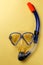 Diving equipment. Snorkeling mask and tube on yellow background. Colorful background