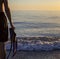 Diving Fins on the Background of the Ocean in the Hands of a Guy. A guy with fins for Scuba Diving lies on the Sandy Shore Against