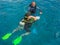 Diving instructor checks equipment for scuba diver before diving to depth. Emerald water Red Sea near Aqaba resort, in Jordan