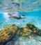 Diving teenage boy snorkeling over the coral reefs underwater photo in the clean turquoise lagoon on Le Morne beach. Mauritius