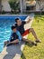 Divorced single dad with his dark-skinned Latino son spend quality time swimming in the pool and sunbathing on their vacation