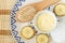 Diy banana mask face cream in the small white bowl, wooden hair brush, cotton pads and banana slices.