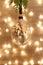 Diy baubles filled dried florals, grass, toy hanging on green plant fern. Bright Glass Christmas ornaments on blur bokeh