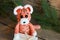 DIY Christmas decor 2022, year of the tiger, crocheted orange tiger sits on a wooden background with a gift and looks at