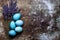 DIY dyed various shades of blue Easter eggs and lavender on retro rusty metal background.